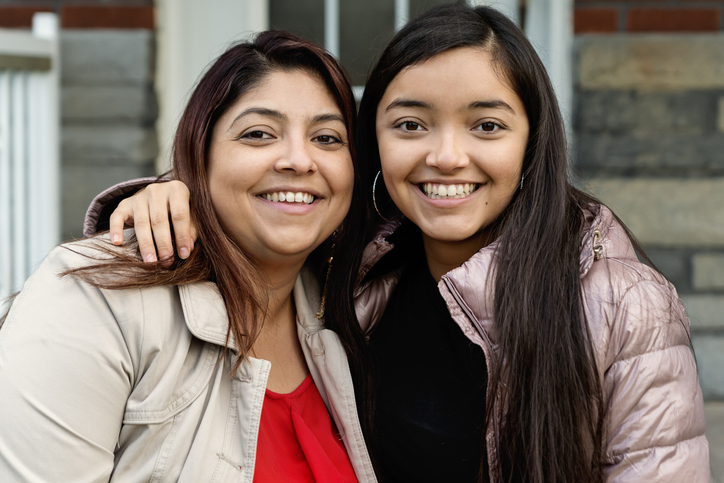 Latina Mom and Daughter smiling about dual enrollment on their homeschool transcript